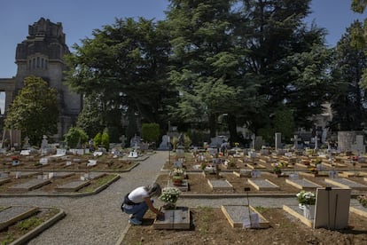 Una mujer coloca flores en la parte del cementerio de Bérgamo donde se enterró a todos los fallecidos por covid-19.