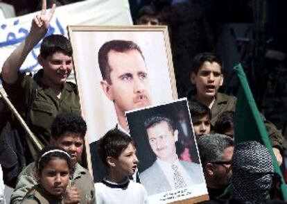 Refugiados palestinos con pósteres de Bachar el Asad se manifiestan ayer en el campo de Yarmuok.