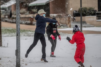 Una mujer y unas niñas juegan con la nieve en el Parque de Enrique Tierno Galván durante una copiosa nevada en Valdemoro.