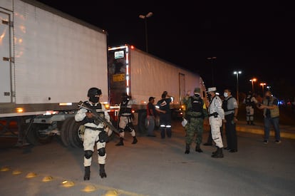 Miembros de la Guardia Nacional custodian los tres camiones en los que viajaban los migrantes.