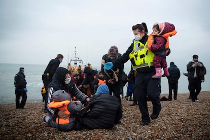 Un agente de fronteras británico ayuda a niños migrantes llegados a Dungeness, Reino Unido, el pasado 24 de noviembre.