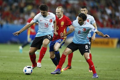 Andrés Iniesta (c) intenta arrebatar el balón a los jugadores turcos.