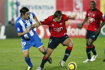 El delantero serbio del Osasuna Savo Milosevic controla la pelota ante el defensa del Málaga Fernando Sanz.