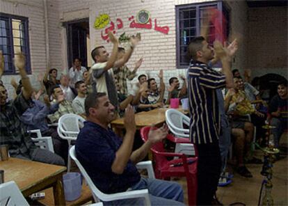 Un grupo de aficionados aplaude a los suyos en un bar de Bagdad.