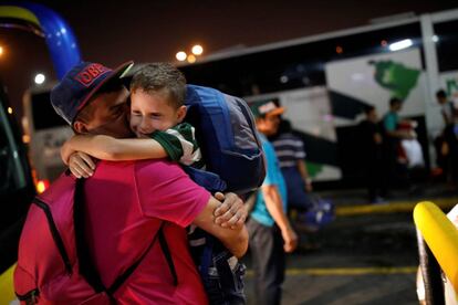 Josmer Rivas, de siete años, es abrazado por su padre tras viajar con su madre en autobús procedente de Caracas (Venezuela) a Guayaquil (Ecuador).