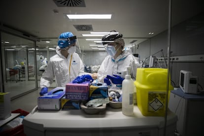 Dos enfermeras revisan material sanitario en una de las UCI del hospital Isabel Zendal.