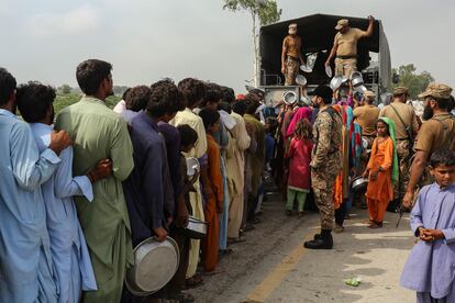 El personal del ejército distribuye alimentos a las personas afectadas por las inundaciones cerca de un campamento improvisado en la provincia de Punjab, el sábado.