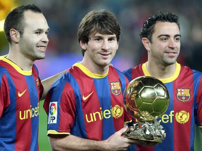 Andrés Iniesta, Leo Messi y Xavi Hernández posan con el Balón de Oro, en el estadio del Nou Camp, el 12 de enero de 2011.