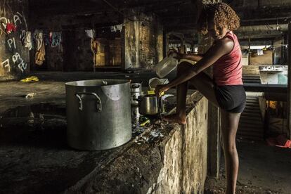 Una niña lava los platos en la escalera principal del edificio okupado del IBGE en la favela Mangueira, Río de Janeiro, Brasil. La mayoría de las 100 familias que viven en el edificio tienen que coger agua de un número limitado de puntos del inmueble a los que llega el agua corriente, ya que la mayoría de los apartamentos no tienen.