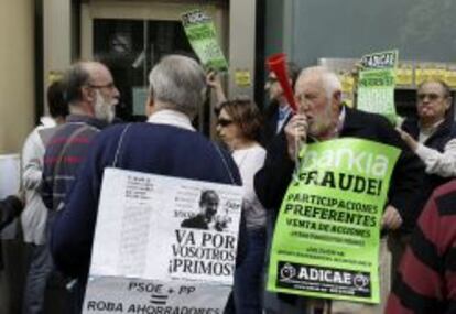 Un grupo de personas protesta a las puertas de una oficina de Bankia, en la madrile&ntilde;a calle de Gran V&iacute;a.