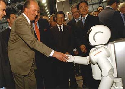 El rey Juan Carlos I saluda a Asimo, el robot humanoide de Honda.