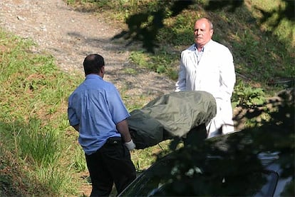 Dos personas llevan el cadáver de Manuel Apaolaza, hallado a las afueras de San Sebastián.