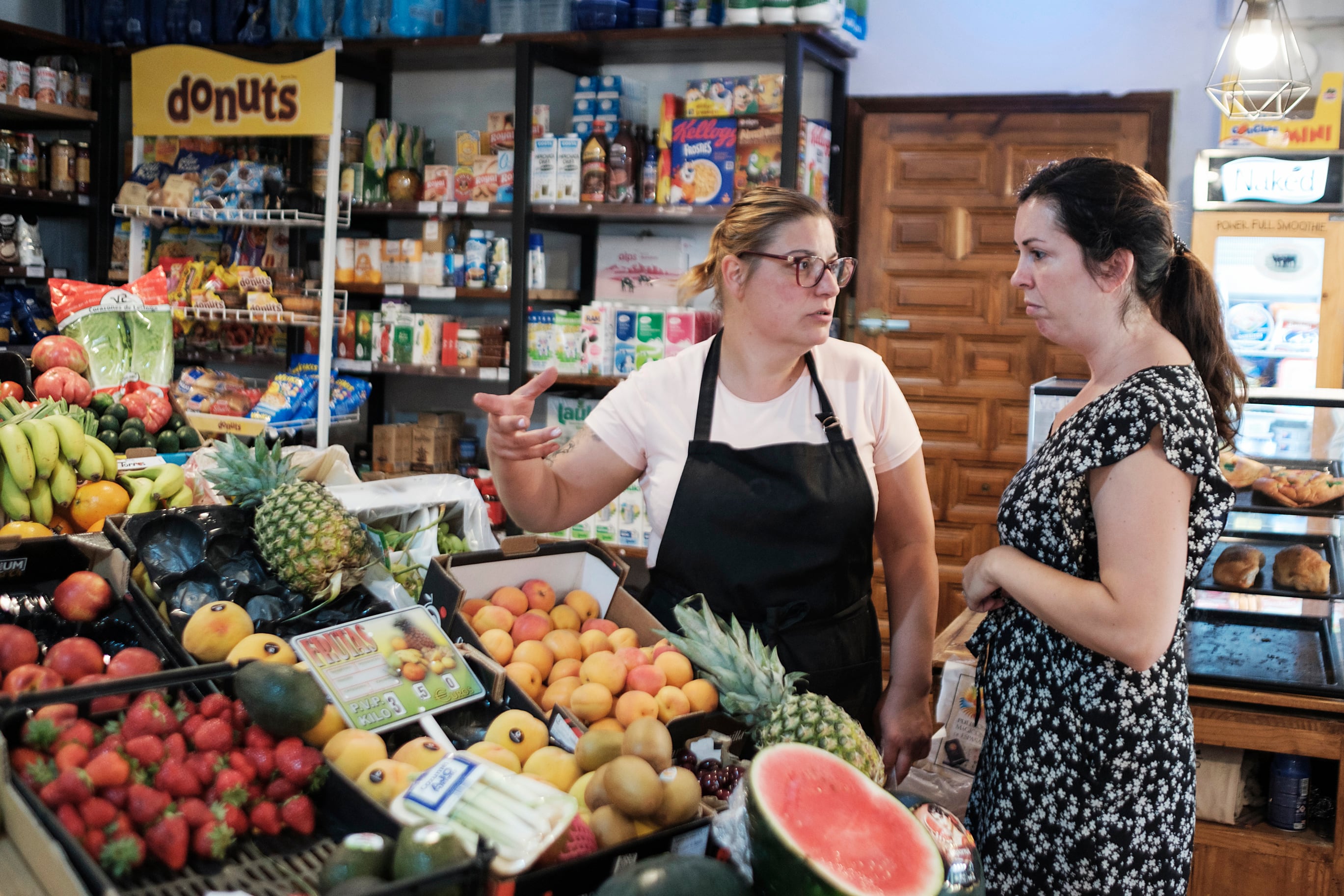 Laura and a customer from the supermarket she runs in Arbancón.