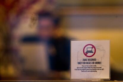 Un cartel sobre una mesa en Federal Café, en Madrid, prohíbe el uso de ordenadores.