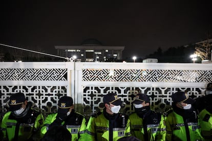 Varios agentes de las fuerzas de seguridad surcoreanas hacen guardia frente a las puertas de la Asamblea Nacional, en Seúl.