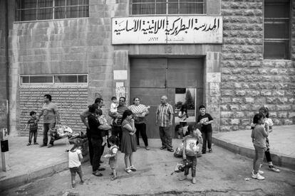 Familias iraquíes en la entrada al colegio e iglesia del padre Carlos en Marqa, Ammán, Jordania. Ellos son algunos de los muchos cristianos que han huído de su país por la amenaza del Estado Islámico, pues castiga con la muerte a quienes no se convierten a la religión musulmana.
