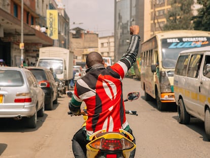 Boniface Mwangi conduce una motocicleta en el barrio de Stahere, en Nairobi, durante los actos de campaña electoral para los que se postuló como parlamentario.