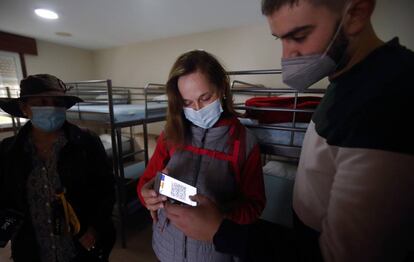 Turistas muestran su certificado Covid en un hostal en Galicia.