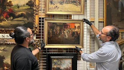 Dos conservadores de la Casa de Colón con el cuadro incautado a Pedro Rico, 'Cruz de mayo', de Eugenio Lucas, en una imagen facilitada por el Cabildo de Gran Canarias.