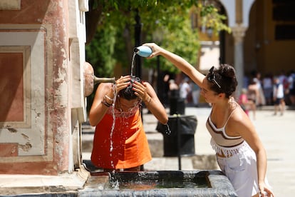  Dos mujeres se refrescan en una fuente del Patio de los Naranjos de la Mezquita Catedral de Córdoba, este martes.
