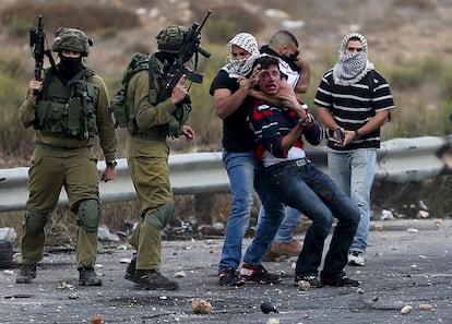 Miembros de la seguridad israelí infiltrados (a la derecha) y soldados israelíes detienen a un manifestante palestino herido durante los enfrentamientos en el asentamiento judío de Bet El, cerca de la ciudad de Ramala (Cisjordania). La tensión entre israelíes y palestinos aumenta, después de 10 días de violencia. El primer ministro israelí, Benjamín Netanyahu, ha cancelado un viaje que tenía planeado realizar a Alemania, han confirmado a Reuters fuentes del Gobierno alemán.