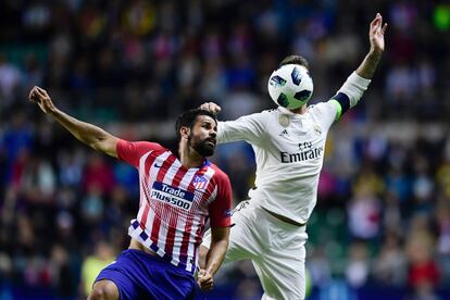 El defensa español del Real Madrid Sergio Ramos cabecea el balón ante Diego Costa.
