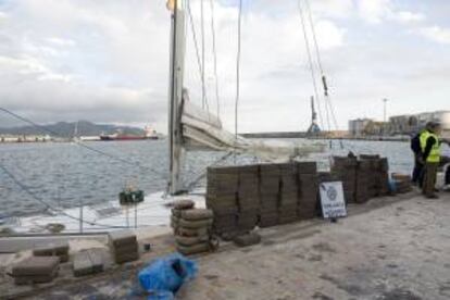 Un agente del Servicio de Vigilancia Aduanera (SVA) de Motril (Granada), junto a los cerca de 1.500 kilos de polen de hachís que fueron intervenidos en un doble fondo del velero "Wiwi", de bandera inglesa. EFE/Archivo