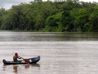 Homem rema em uma balsa na Amazônia brasileira.