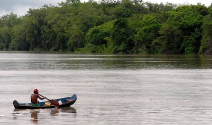 Homem rema em uma balsa na Amazônia brasileira.