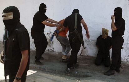 Terroristas de Hamás ponen de rodillas a dos palestinos delante de una pared para dispararles después.