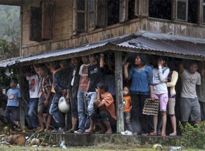 Supervivientes del terremoto se protegen de la lluvia bajo uno de los inmuebles que resistieron al seísmo en la localidad de Pariaman.