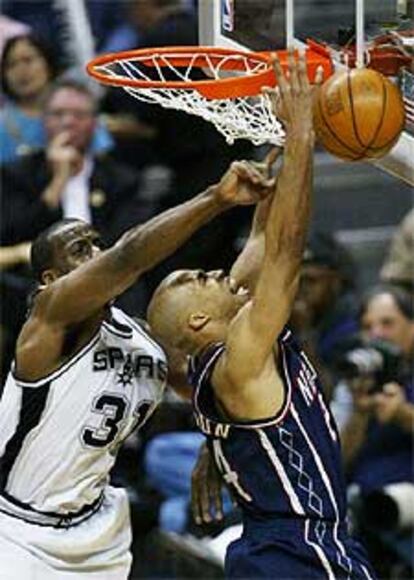 El jugador de los Spurs Rose (izqda.) pone un tapón a Jefferson.