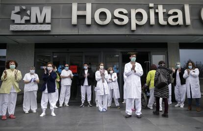 El personal sanitario guarda un minuto de silencio por las víctimas del coronavirus, este lunes a la entrada del hospital La Paz de Madrid.
