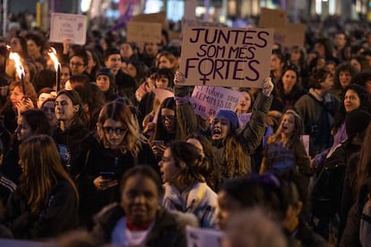 Una manifestante durante la marcha en Barcelona, con una pancarta en catalán en la que se lee "Juntas somos más fuertes".