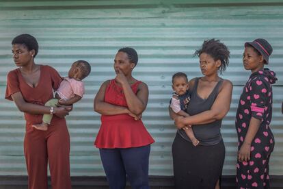 Una fila de mujeres espera a la distribución de alimentos en el asentamiento informal de Nkanini en Durban, Sudáfrica, el 22 de abril de 2022.