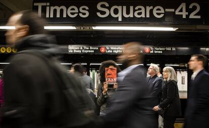 Una mujer muestra el libro 'Fear, Trump in the White House' en el metro de Nueva York.