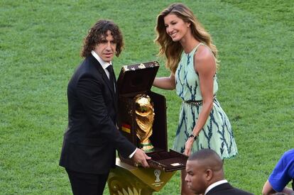 O ex-jogador de futebol Carles Puyol e a modelo brasileira Gisele Bundchen foram os responsáveis por levar a taça da FIFA.