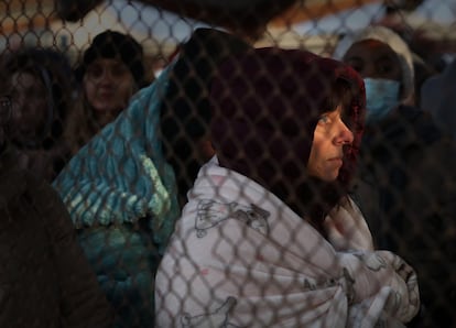 Decenas de personas procedentes de Ucrania, tras la verja de la estación  de Przemysl en Polonia, donde han llegado varios trenes con refugiados.