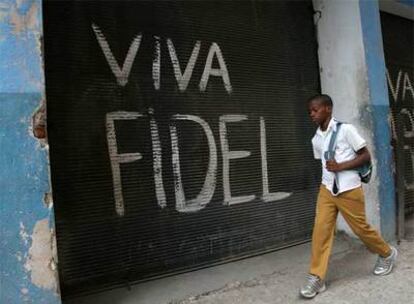 Un estudiante pasa por delante de una pintada a favor de Fidel Castro en la capital cubana.