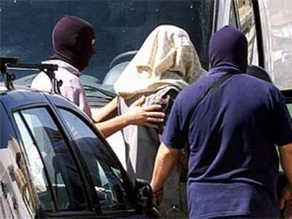 Momento en el que la policía detenía ayer en Granada al sirio Hamal Hussein Hussein, en el centro, con la cabeza cubierta.