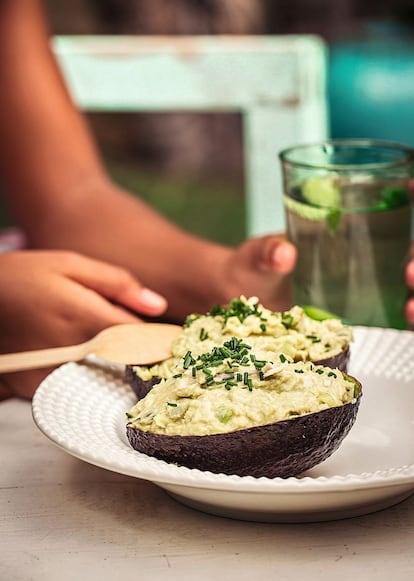 <p><i>Ingredientes</i></p><p> Para 4 personas: un pollo asado envasado, 4 aguacates, una cebolla, un limón, 75 gramos de pepinillos en vinagre, una cucharada de sésamo, unas ramitas de cebollino, mostaza de Dijon al gusto (opcional), sal y pimienta. </p><p><i> Preparación </i></p><p> Quitarle la piel al pollo y sacarle toda la carne, desmigándola bien con las manos. Pelar y picar fina la cebolla y los pepinillos. Abrir los aguacates por la mitad, reservando las cáscaras. Sacarles la carne y mezclarla con la cebolla, los pepinillos, el zumo del limón, la carne del pollo, el sésamo, la mostaza –si se quiere–, sal y pimienta. Rellenar las cáscaras y servir con cebollino picado por encima. Puede sustituirse el pollo por bonito en conserva, queso feta o salmón ahumado. </p>