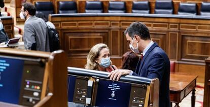 El presidente del Gobierno, Pedro Sánchez (i) y la ministra de Economía y vicepresidenta tercera del Gobierno, Nadia Calviño (d), conversan en el Parlamento antes de intervenir en la sesión de Control al Gobierno celebrada en el Congreso de los Diputados.