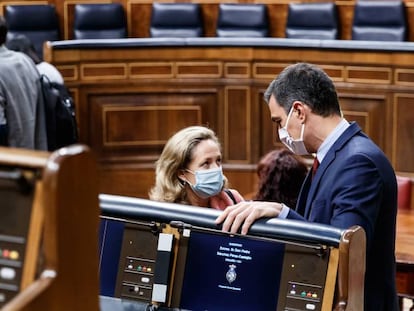 El presidente del Gobierno, Pedro Sánchez (i) y la ministra de Economía y vicepresidenta tercera del Gobierno, Nadia Calviño (d), conversan en el Parlamento antes de intervenir en la sesión de Control al Gobierno celebrada en el Congreso de los Diputados.