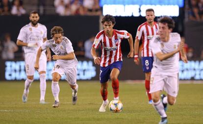 João Félix conduce la pelota perseguido por Modric.