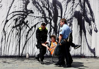 Agentes de la policía sacaban en volandas a un activista de la Generación Letzte (última) después de que derramara un líquido negro, que simboliza el petróleo, para protestar por el fin de los combustibles fósiles y contra la extracción de petróleo en el mar del Norte, en Berlín, Alemania, este miércoles.