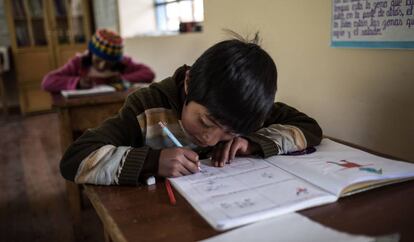 Un niño hace los deberes durante una clase en el colegio de Huaycho, una localidad campesina de Puno, en Perú.