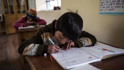 Un niño hace los deberes durante una clase en el colegio de Huaycho, una localidad campesina de Puno, en Perú.