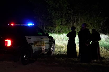 Sacerdotes de la Arquidiócesis de San Antonio rezan a unos metros de donde fue hallado el camión con remolque.