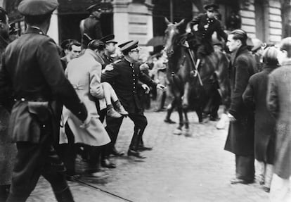 Varias personas evacuan a un niño herido en un tiroteo tras el entierro del policía José del Castillo, teniente de la Guardia de Asalto, el 14 de julio de 1936.