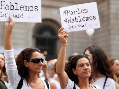 Dos mujeres sostienen carteles a favor del di&aacute;logo este s&aacute;bado en Barcelona.